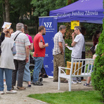 Mieszkańcy stoją w kolejce do stoiska NFZ.