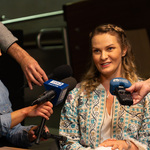 Wywiadu udziela Ania Chomczyk „Joginka w Podroży, obok stoją dziennikarze z mikrofonami.