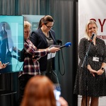 Kobieta udziela wywiadu podczas konferencji prasowej, obok stoją inni uczestnicy.