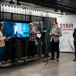 Dyrektor Muzeum Pamięci Sybiru Wojciech Śleszyński udziela wywiadu podczas konferencji prasowej, obok stoją inni uczestnicy wydarzenia.