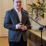 Mężczyzna mówi do mikrofonu podczas uroczystości.