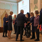 Prezydent Miasta Białegostoku po kolei wręcza listy gratulacyjne osobom stojącym w szeregu.