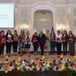 Nauczyciele wyróżnieni podczas uroczystości stoją z listami gratulacyjnymi w dłoniach.
