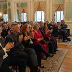 Uczestnicy wydarzenia siedzą na krzesłach w Auli Magna, w pierwszym rzędzie siedzą przedstawiciele Miasta i instytucji..