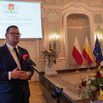 Zastępca prezydenta Tomasz Klim mówi do mikrofonu podczas uroczystości.