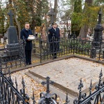 Zastępca prezydenta Rafał Rudnicki trzyma w dłoniach zapalony znicz