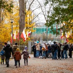 Grupa dzieci stoi przy bramie cmentarza