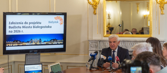 Prezydent Tadeusz Truskolaski siedzi przy stole podczas konferencji prasowej