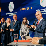 Mężczyzna odczytuje laureatów 