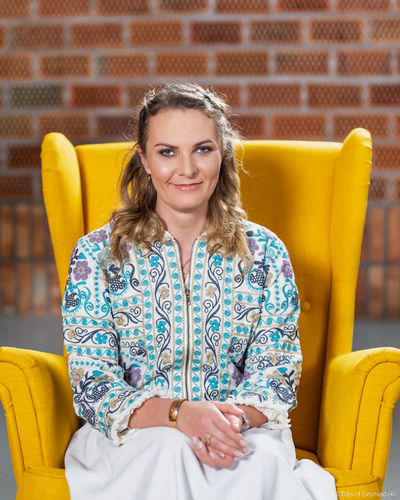 Ania Chomczyk siedzi w żółtym fotelu.