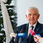 Prezydent Tadeusz Truskolaski rozmawia z dziennikarzem. W tle widać choinkę i mikrofony z logo mediów.