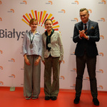 Dwie uśmiechnięte dziewczyny prezentują otrzymane medale. Obok stoi zastępca prezydenta Rafał Rudnicki bijący brawo