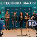 Uczestnicy konferencji prasowej stoją na tle ścianki Politechniki Białostockiej 