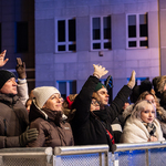 Publiczność stoi za barierkami.
