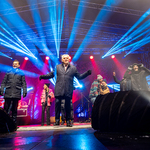 Prezydent Tadeusz Truskolaski stoi na scenie, w tle stoją inni uczestnicy wydarzenia.