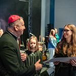 Metropolita białostocki abp Józef Guzdek wręcza dyplomy dziewczynkom.