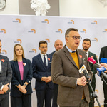 Zastępca prezydenta Rafał Rudnicki udziela wywiadu przed mikrofonami podczas konferencji prasowej.