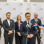 Wojewoda Jacek Brzozowski udziela wywiadu podczas konferencji, w tle stoją inni uczestnicy.