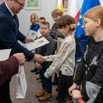 Zastępca prezydenta Tomasz Klim wręcza dzieciom listy gratulacyjne.