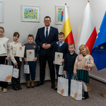 Zastępca prezydenta Tomasz Klim stoi wśród grupy kilkorga dzieci nagrodzonych w konkursie.