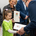 Zastępca prezydenta Tomasz Klim wręcza dziewczynce wyróżnionej w konkursie list gratulacyjny.