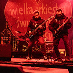 Dwóch mężczyzn gra na gitarach na scenie 