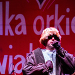 Artysta na scenie trzyma w dłoni mikrofon 