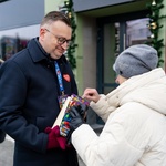 Kobieta wkłada pieniądze do puszki, którą trzyma w dłoniach zastępca prezydenta Rafał Rudnicki 
