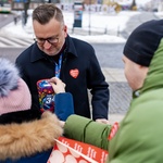 Mieszkańcy wrzucają pieniądze do puszki, którą trzyma w dłoniach zastępca prezydenta Rafał Rudnicki 