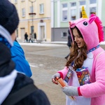 Uśmiechnięta wolontariuszka ubrana w różowy strój jednorożca podczas zbierania pieniędzy na Wielką Orkiestrę Świątecznej Pomocy