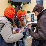 Starszy mężczyzna wkłada pieniądze do puszki WOŚP