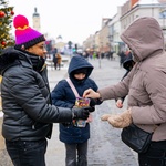 Białostoczanka wrzuca do puszki pieniądze. W roli wolontariusza Gracjan Paweł Eshetu-Gabre