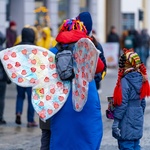 Kobieta mająca na plecach duże, przezroczyste skrzydła oklejone czerwonymi serduszkami WOŚP