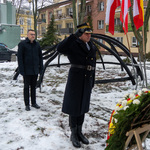 Zastępca prezydenta Rafał Rudnicki oddaje hołd pod Pomnikiem Wielkiej Synagogi, obok stoi salutujący strażnik miejski 