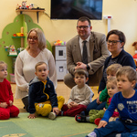 Nauczycielki, dzieci oraz zastępca prezydenta Tomasz Klim siedzą na dywanie 