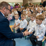 Zastępca prezydenta Tomasz Klim podaje dłoń uczniowi, w tle dzieci 