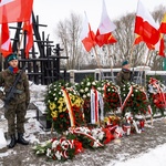 Warta honorowa stoi przy Pomniku w Hołdzie Ofiarom Sybiraków. Przy pomniku leżą wieńce z kwiatów oraz znicze 