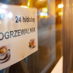 Kartka z napisem Ogrzewalnia 24/dobę znajduje się na oknie autobusu 