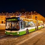 Zielono biały autobus Białostockiej Komunikacji Miejskiej stoi na Rynku Kościuszki wieczorową porą 