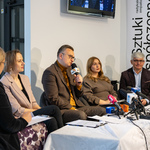 Pięciu uczestników konferencji prasowej siedzi przy stole, zastępca prezydenta Rafał Rudnicki mówi do mikrofonu.
