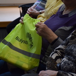 seniorzy trzymają elementy odblaskowe