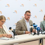 Zastępca prezydenta Tomasz klim mówi do mikrofonów stojących na stole podczas konferencji prasowe, obok siedzą inne osoby.