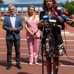 Kobieta mówi do mikrofonów podczas konferencji prasowej.