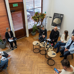 Uczestnicy konferencji siedzą przy stolikach, widok z góry na salę.