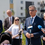 Mężczyzna mówi do mikrofonów podczas konferencji prasowej.