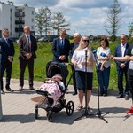 Mieszkanka bloków komunalnych udziela wywiadu stojąc przed mikrofonami.