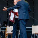 Prezydent Tadeusz Truskolaski wskazuje ręką w bok sceny.