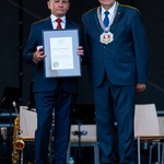 Jerzy Cywoniuk trzyma w rękach ramę z odznaczeniem, obok stoi prezydent Tadeusz Truskolaski.