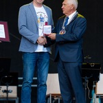 Łukasz Leoniuk trzyma medal Urbi Meritus, obok stoi prezydent Tadeusz Truskolaski.