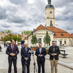 Uczestnicy konferencji stoją przed mikrofonami na Rynku Kościuszki.